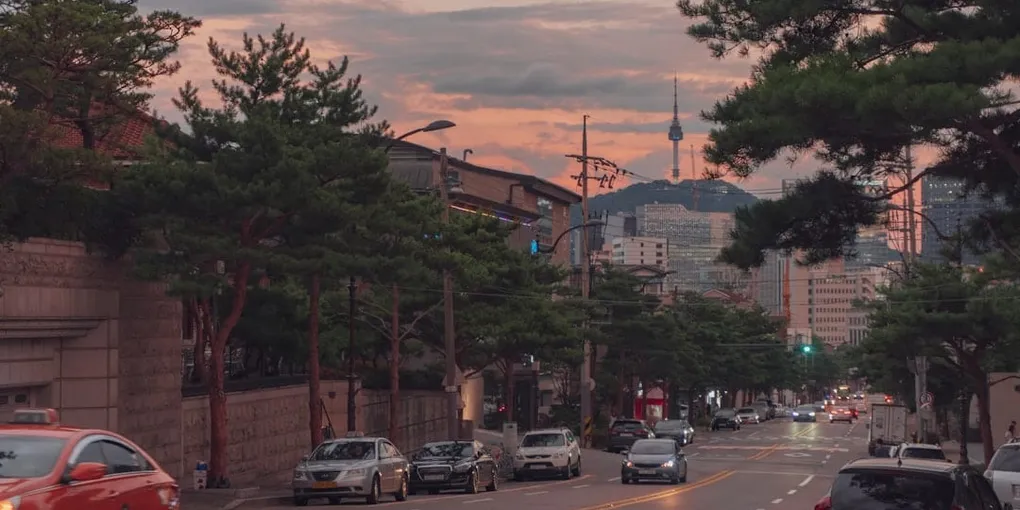 A Seoul street and N Seoul Tower under a hot summer evening sky